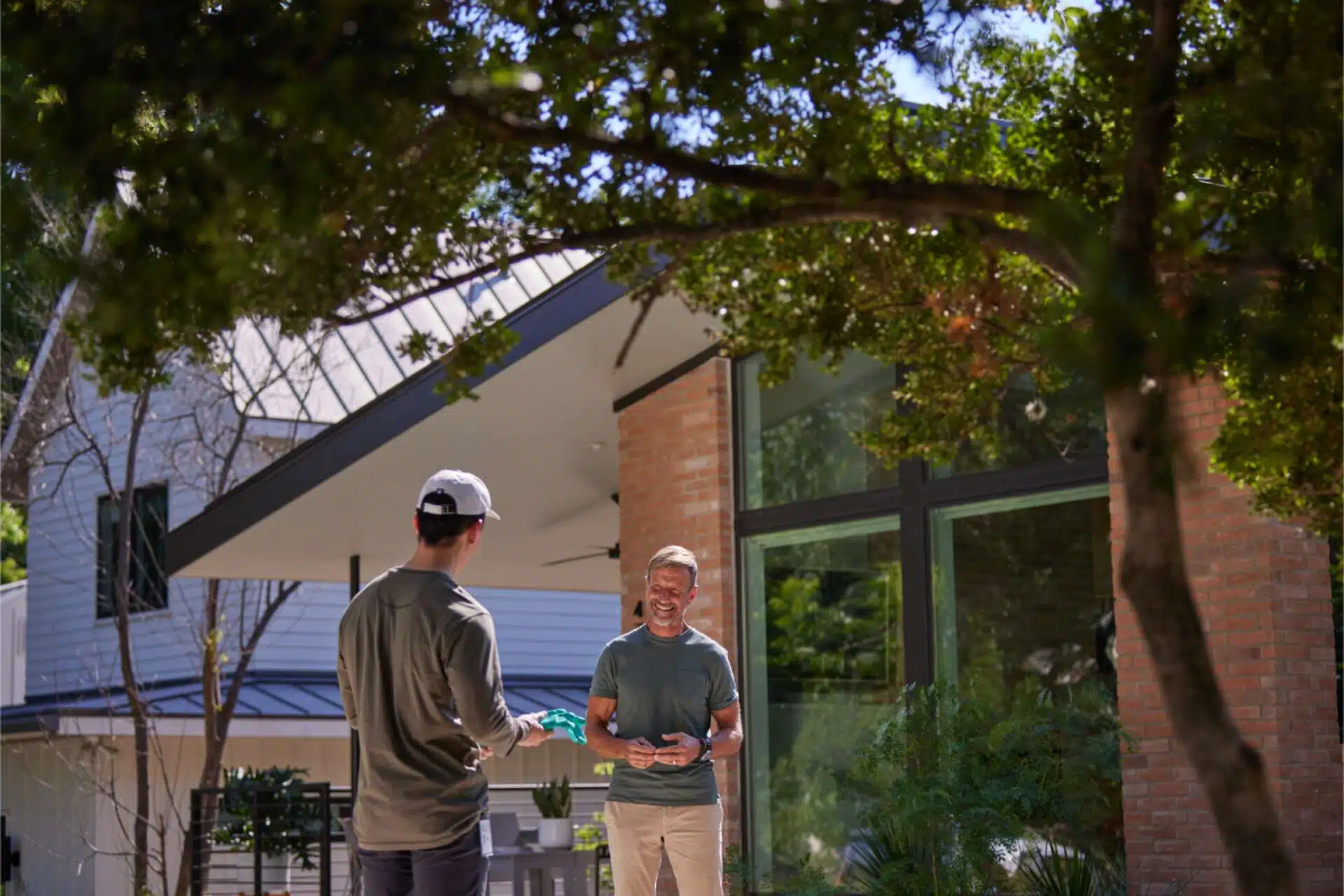 Aptive Employee Standing In The Front Yard Talking To A Customer.