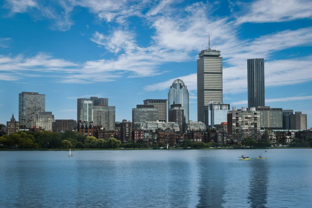 Boston Skyline And Back Bay Brownstones Viewed Across The Charles River With Kayakers On The Water